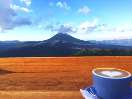 a cup of cappuccino and view of mount batur, its a perfect momentのeditorial素材