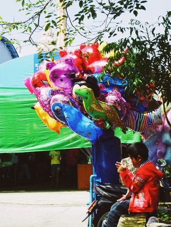 Colorful balloons with a boy in the Thai temple festivalの素材