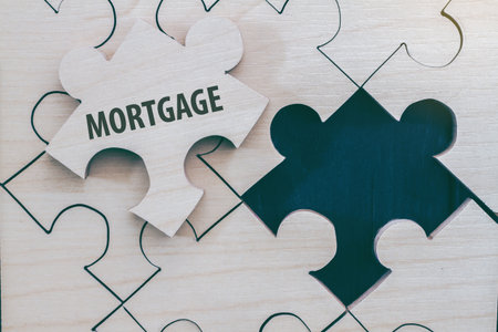 Wooden tangram puzzle home, Write the word "mortgage" shape dream home, happy life, house. planning savings a home concept for property, mortgage and real estate investment. for saving for a house.の写真素材
