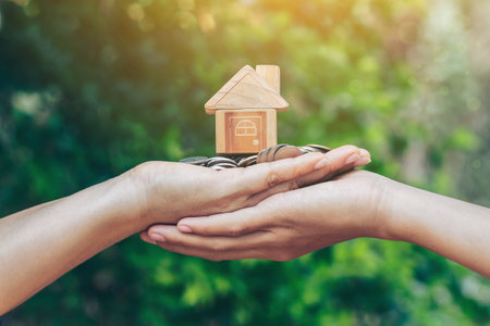Home loan, home insurance, family life assurance protection, financial mortgage for house building, and legacy planning investment concept with children - parent's hands holding private propertyの写真素材