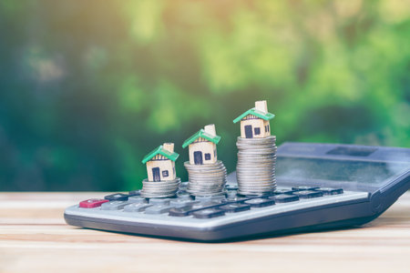 House is placed on a coin as a ladder, is on the calculator. planning savings money of coins to buy a home concept for property ladder, mortgage and real estate invest, saving for a buy house.の写真素材