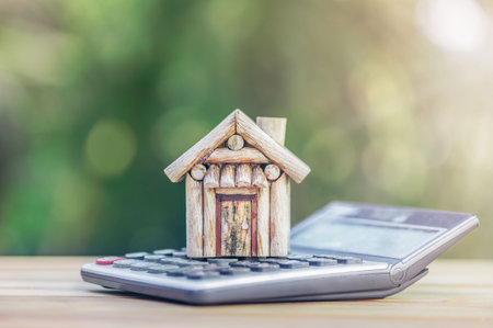 House is placed on the calculator. Imagine calculating to buy a home. planning savings money of coins to buy a home concept for property, mortgage and real estate investment.to buy a house.の写真素材
