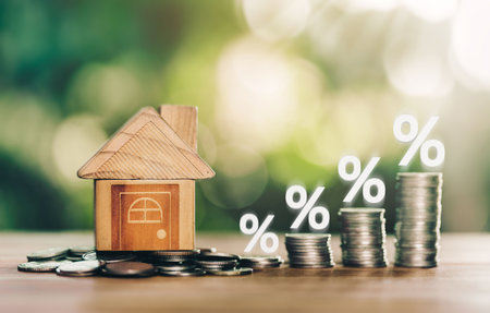 House and coins place on the wood table is ladder with white illustration shows decreasing of interest rates. planning savings money of coins to buy a home concept for property ladder, mortgage.の写真素材