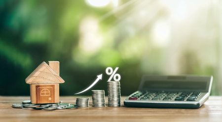 House is placed on the coins. Stacked Coins on wooden table with white illustration shows increasing of interest rates increase. planning savings money of coins to buy a home concept for property.の写真素材