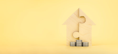 Mortgage concept property. coins are stacked in front of the house puzzles. planning savings a home concept for property, mortgage and real estate investment for house. home shape for build dream homeの写真素材