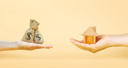 Loans for real estate concept, a man and a woman hand holding a money bag and a model home put together. planning savings money of coins to buy a home concept for property mortgage. Home loan.の写真素材