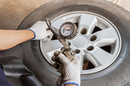 mechanic hands with tool, changing tyre of car Maintenance male checking tire service via insurance system at garage, Safety vehicle to reduce accidents before a long travel.の写真素材