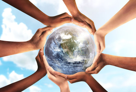 Conceptual symbol of multiracial human hands surrounding the Earth globe. Unity, world peace, humanity concept. World environment day- Earth Day concept.の写真素材
