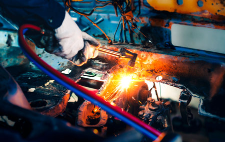 Close up hand heavy industrial worker is working on metal work factory process by Cutting sheet steel with gas cutting machine cutting thick steel in boilermakers workshop.の写真素材