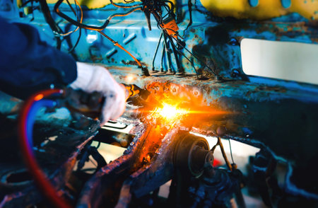 Close up hand heavy industrial worker is working on metal work factory process by Cutting sheet steel with gas cutting machine cutting thick steel in boilermakers workshop.の写真素材