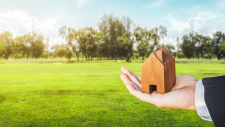 House symbol with location pin on Empty dry cracked swamp reclamation soil, land plot for housing construction project, property investment concept, Buying new home for family. Land for sales concept.の写真素材