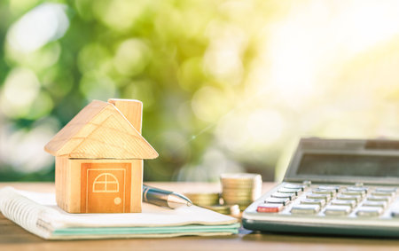 House placed on coins. notebook and pen Prepare planning savings money of coins to buy a home concept for property ladder, mortgage and real estate investment. for saving or investment for a house.の写真素材