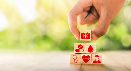 Hand arranged wooden blocks with icons of medical health. health insurance for your health concept. Healthcare medical business, medical technology equipment icon, health care protection concept.の写真素材