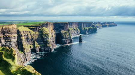 The breathtaking Cliffs of Moher in Ireland, towering over the wild Atlantic Ocean, with lush green landscapes.の素材