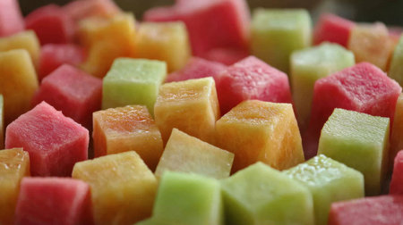 A vibrant assortment of fresh fruit cubes including watermelon, cantaloupe, and honeydew. Perfect for a healthy snack, summer gatherings, or eye-catching presentations.の素材