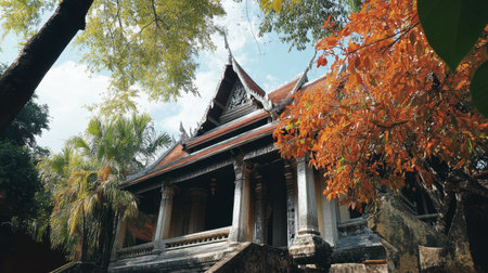 A beautiful traditional temple surrounded by lush trees and vibrant autumn foliage, showcasing unique architecture set against a serene sky.の素材