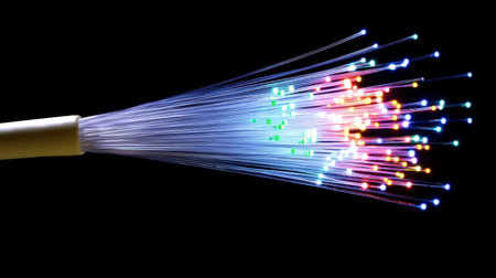 A vibrant display of colorful fiber optic lights emerging from a single source against a dark background, representing technology and innovation in visual art.の素材