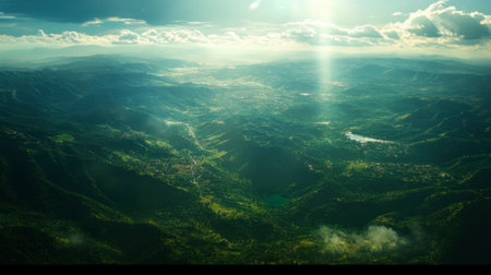 A breathtaking aerial perspective showcasing a lush green valley surrounded by majestic mountains, illuminated by gentle sunlight. A perfect snapshot of nature's beauty.の素材