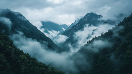 A majestic view of a mountain range with dense clouds rolling over the peaks, creating a dramatic and mystical atmosphere.の素材