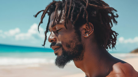 A man with beautifully styled dreadlocks standing on a sandy beach, his hair swaying in the ocean breeze.の素材