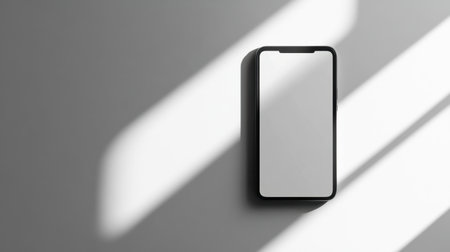 A sleek, modern smartphone placed on a plain white background, casting a subtle shadow, ideal for showcasing technology.の素材