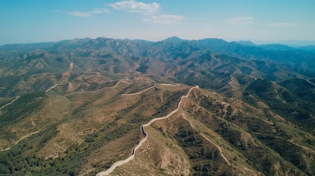 Discover a stunning aerial view showcasing rugged mountains and winding roads, perfect for nature enthusiasts and travel lovers seeking adventure and tranquility.の素材