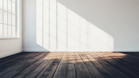 A spacious room featuring a wooden floor and bright sunlight casting shadows. Perfect for showcasing minimalistic and modern interior designs.の素材