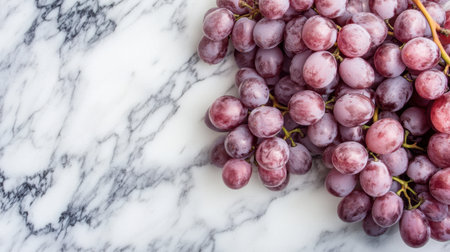 A beautiful arrangement of fresh purple grapes on a marble surface, showcasing their natural texture and vibrant colors. Perfect for food-themed projects.の素材
