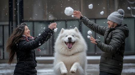 A couple playfully throwing snowballs near their fluffy white dog in a charming urban plaza.の素材