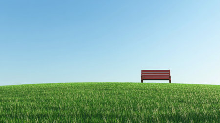 A grassy hilltop under a cloudless sky, with a single wooden bench.の素材