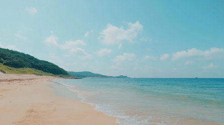 Experience the tranquility of a calm beach with gentle waves lapping against the shore and vibrant blue skies, perfect for serene getaways and relaxation.の素材