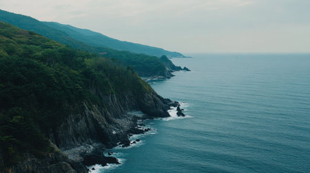 Explore a breathtaking coastal scene featuring rugged cliffs and calm ocean waves, framed by lush greenery and a moody sky, capturing nature's serene beauty.の素材