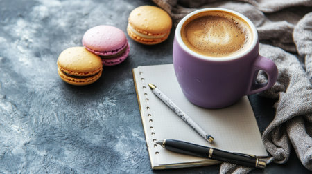 A comforting scene featuring a purple coffee cup filled with rich brew, accompanied by colorful macarons, notepad, and writing tools, evoking creativity and relaxation.の素材