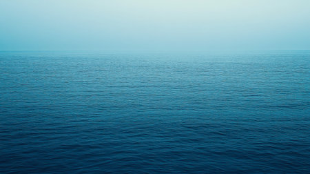 A serene view of an endless ocean with calm waters under a soft blue sky, capturing the essence of tranquility and natural beauty. Perfect for relaxation themes.の素材