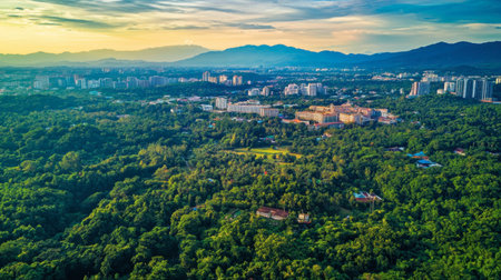 An aerial view showcasing a vibrant cityscape enveloped in lush green vegetation with mountains in the background. This serene landscape embodies harmony between nature and urban development.の素材