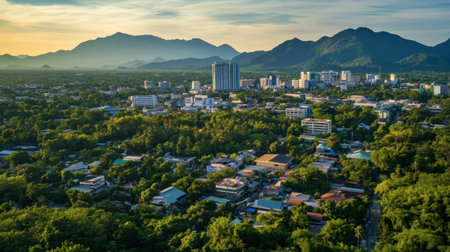 Beautiful aerial view of a city surrounded by mountains, showcasing lush greenery and a vibrant skyline during sunset. Ideal for nature and travel themes.の素材