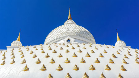A stunning view of a majestic white dome adorned with golden spires against a vibrant blue sky, showcasing intricate details and artistic craftsmanship in architecture.の素材