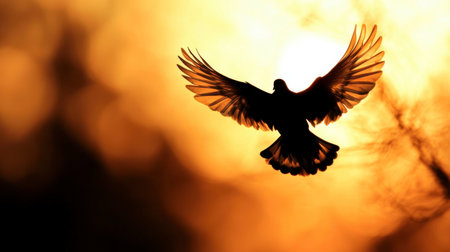 A stunning silhouette of a bird soaring gracefully against a vibrant golden sunset. This image captures the essence of freedom and beauty in nature.の素材