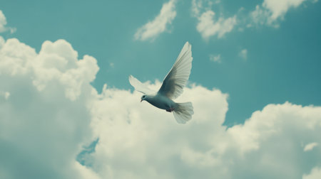 A stunning white dove gracefully soars through a bright blue sky filled with fluffy clouds, symbolizing freedom and peace in nature's serene ambiance.の素材