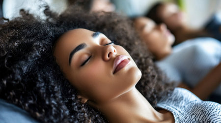 A serene woman with curly hair enjoys a moment of relaxation, embodying tranquility and peace. The soft focus background enhances the calming atmosphere.の素材