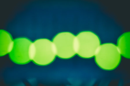 Green glitter sparkle defocused rays lights bokeh abstract sparkling  background.の写真素材