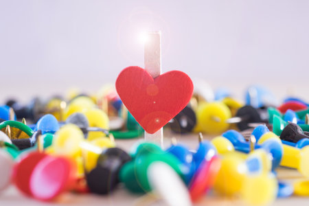 Heart of paper clip with rays flare about love relationship with many pins for background.の写真素材