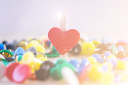 Heart of paper clip with rays flare about love relationship with many pins for background.の写真素材