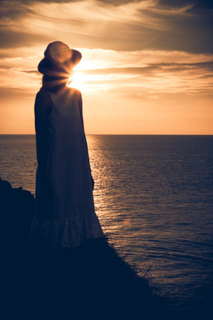 Defocused woman on the beach ray sunrise.の写真素材
