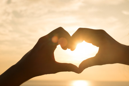 Silhouette hand in heart on sunrise  the sea.の写真素材