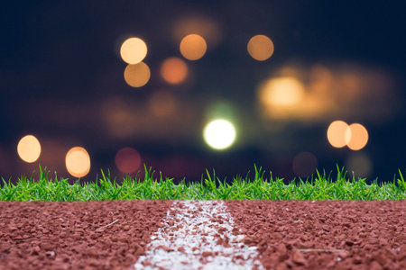 Running track with night glitter rays lights bokeh business background.の写真素材
