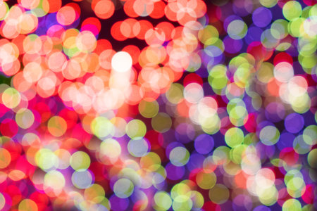 Colorful glitter sparkles defocused rays lights bokeh abstract holiday background.