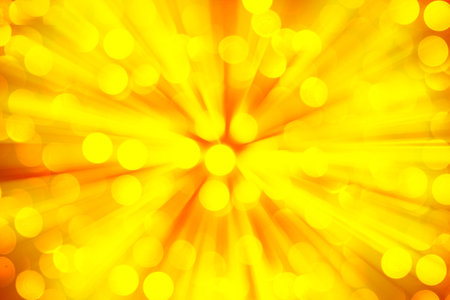 Gold glitter sparkles defocused rays lights bokeh abstract holiday background.の写真素材