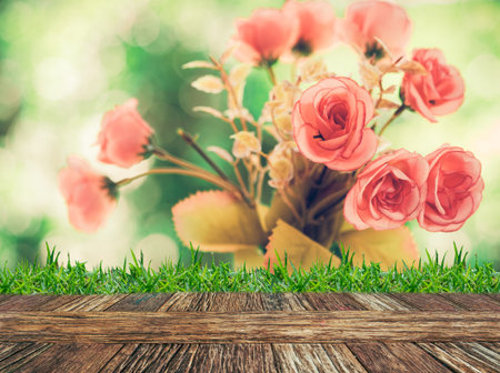 Empty wooden table and grass with beautiful rose nature background. Product display template.の写真素材