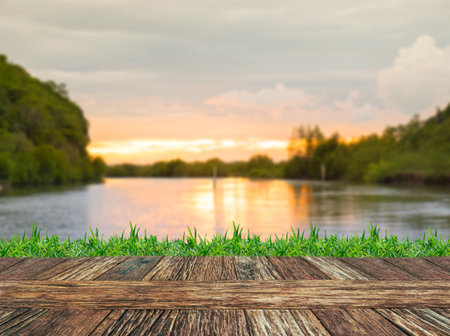 Empty wooden table and grass with river and muontain natural bokeh background. Product display template.の写真素材